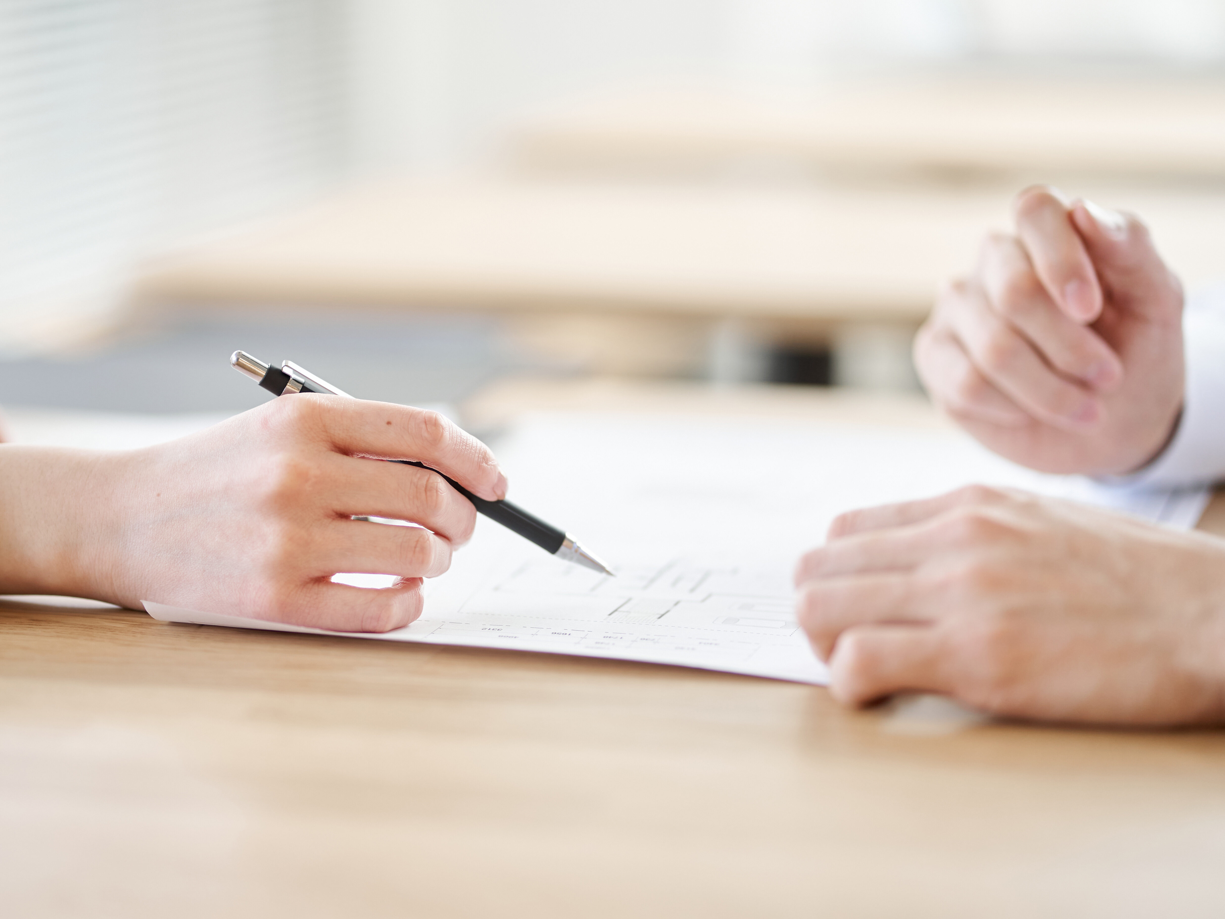 不動産の間取りの説明をするアジア人の不動産